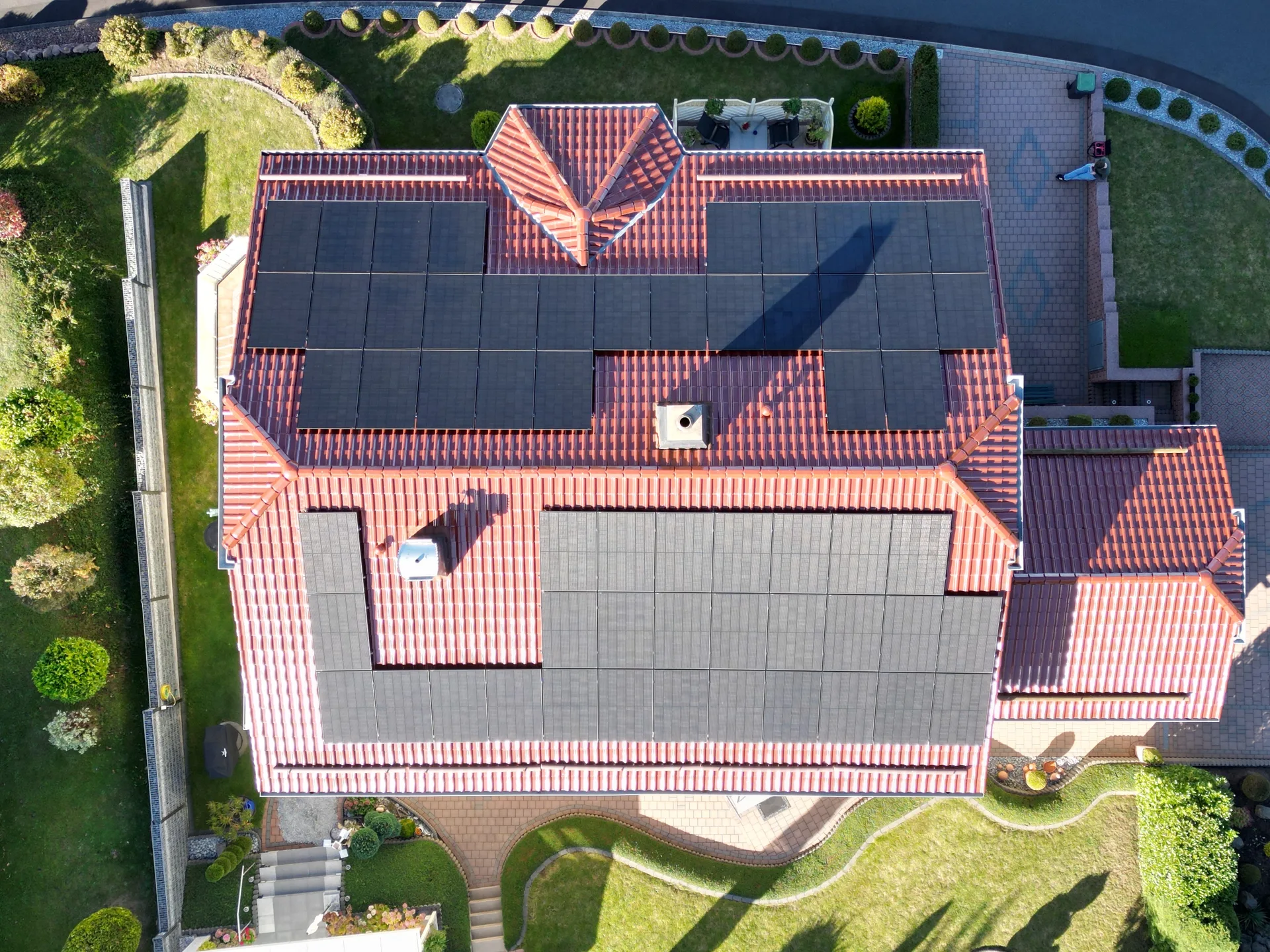 Luftaufnahme eines Hausdachs mit Photovoltaik-Modulen