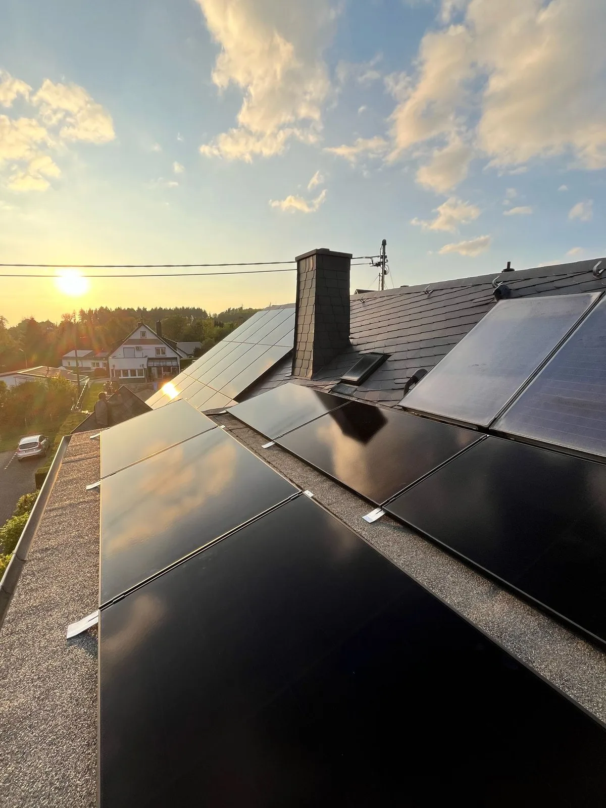 Schwarze Solarmodule auf einem Schieferdach in Bendorf im Abendlicht