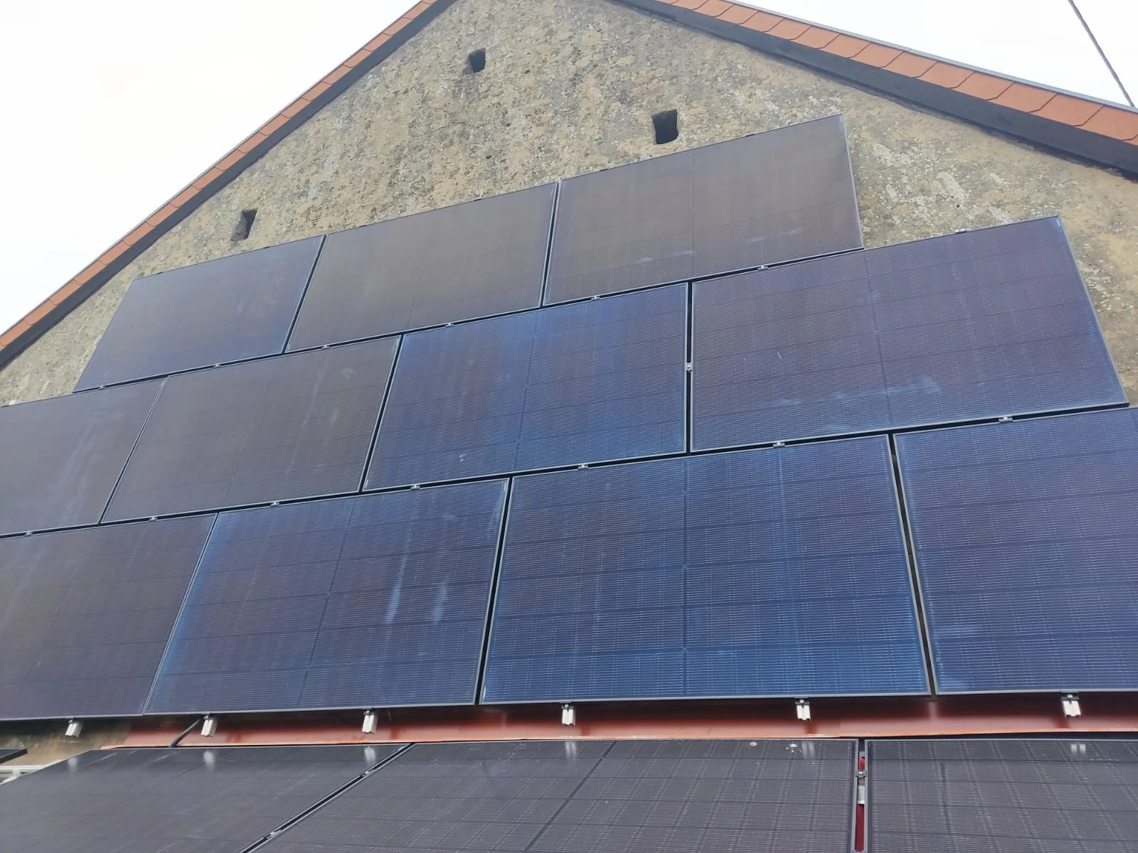 Photovoltaik-Module an Giebelwand und Dach eines Gebäudes – Thiessen Energy