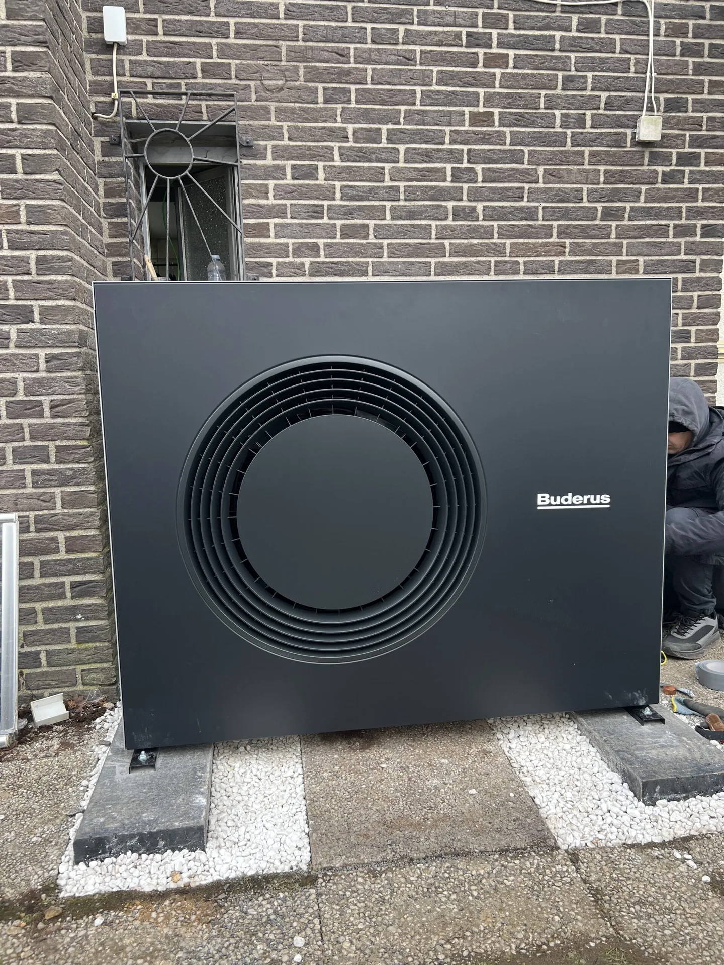 Buderus-Wärmepumpe als Außeneinheit frontal vor einer Klinkerfassade
